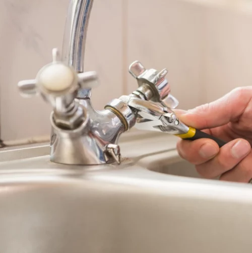 close up plumbers hand fixing a faucet brandon ms